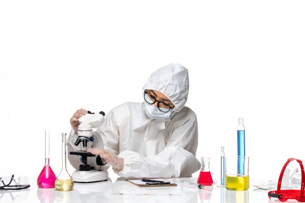 实验室前视图穿着特殊防护服的女化学家检查白色背景上的样本化学冠状病毒-大流行性健康病毒外套检查化学