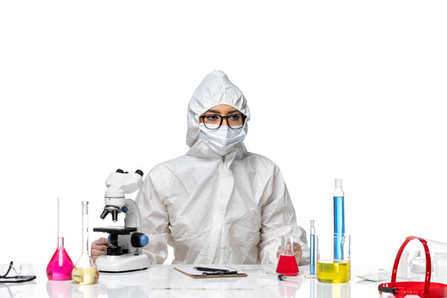保护前视图穿着特殊防护服的女化学家正坐在白色背景上化学冠状病毒-健康病毒坐着药品白色
