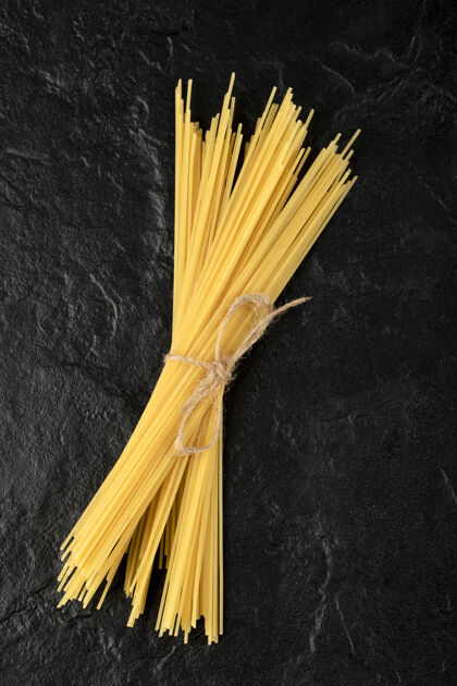 意大利面用绳子绑在黑面上的生意大利面生的新鲜食品