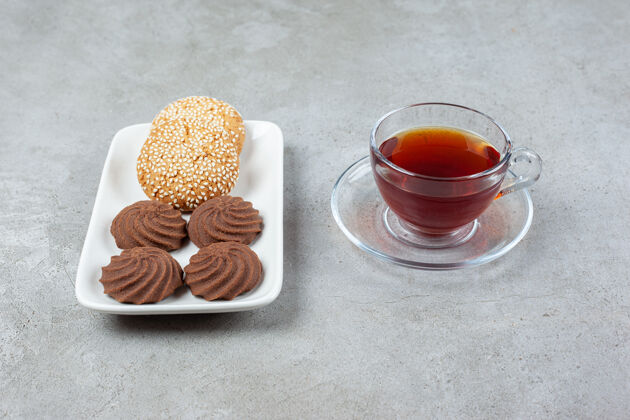 糕点一盘不同的曲奇饼和一杯放在大理石表面的香茶香好吃饼干