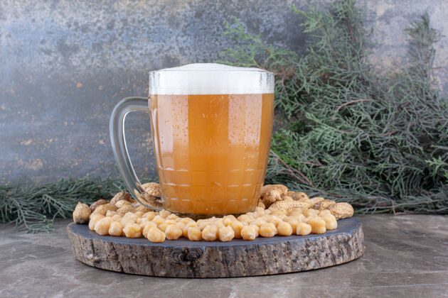 泡沫一杯啤酒 豌豆和花生放在木片上提神零食酒精