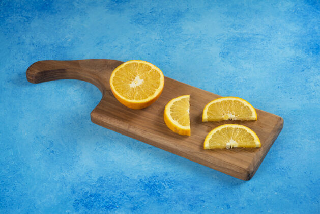 黄色把橘子片放在蓝色的木板上自然免疫力多汁