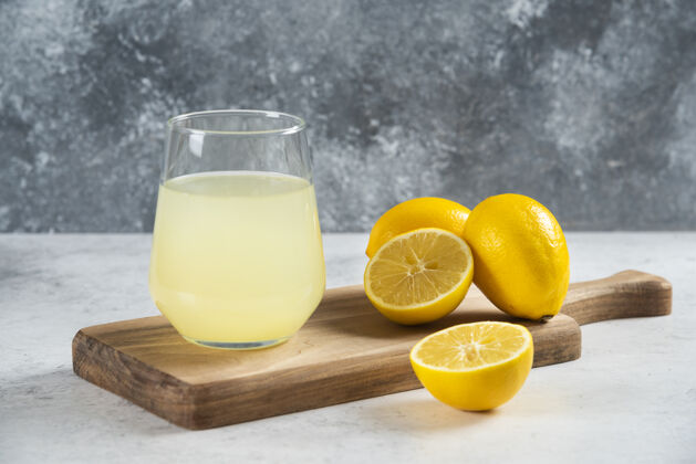 杯子在木板上放一杯新鲜的柠檬汁水水果有机