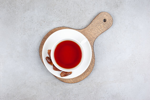 茶一杯茶和一些日期在茶碟上的木板上 大理石表面茶杯茶碟大枣