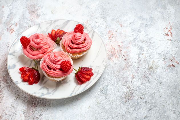 水果正面图白色空间上有粉色草莓蛋糕和新鲜的红色草莓蛋糕红色可食用水果