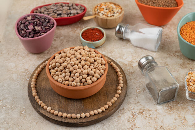 木板一个木制的碗里装满了未经料理的豌豆 还有香料和豆子未煮熟的香料扁豆