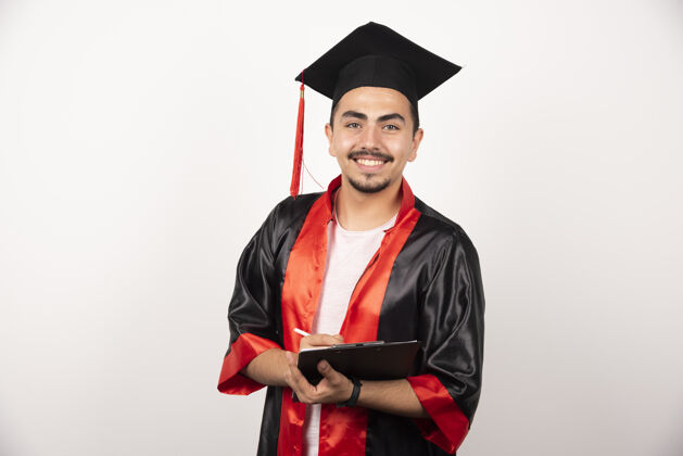 表达正拿着毕业证的研究生看着白色的相机年轻教育帽子
