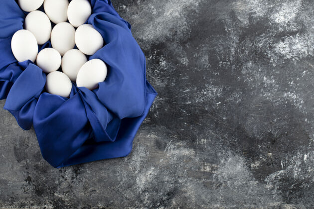 自然在蓝色桌布上放上白色生鸡蛋蛋白质食物鸡