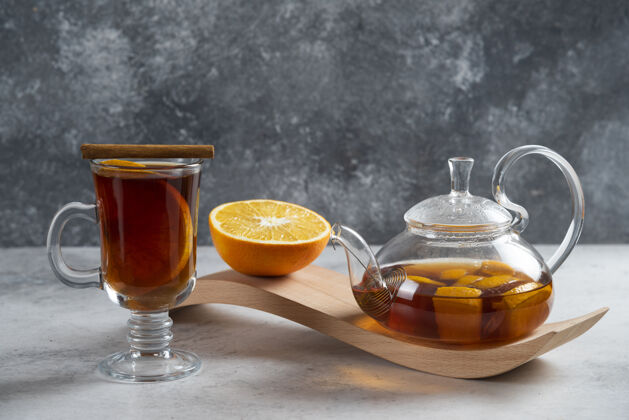 草药一个茶壶 上面放着茶和一片橘子在木板上柑橘水果草药