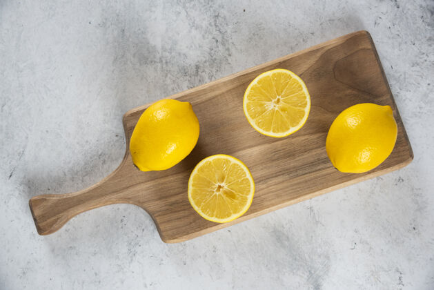整个柠檬用木铰刀把整个柠檬切成片有机美味顶视图