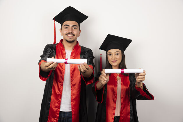 男应届毕业生在白纸上展示毕业证书成就学历女