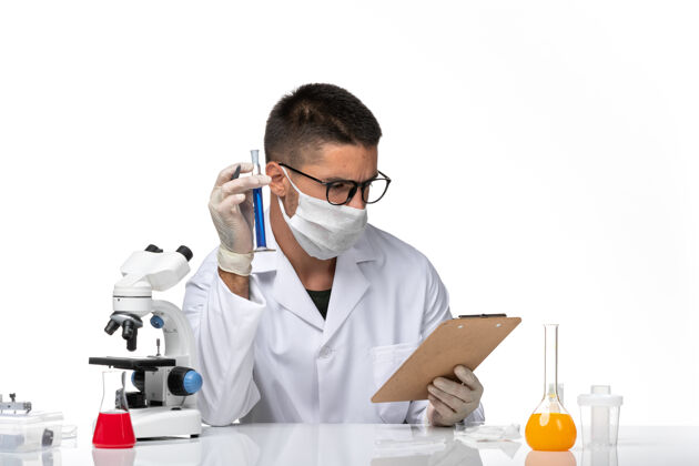 实验室外套正面图男性医生穿着白色医疗服 戴着面罩 因为科维德在一个白色的空间里用溶液工作健康工作溶液