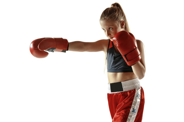 成功年轻的女子跆拳道拳击手在白墙上孤立地训练穿着红色运动服的白人金发女孩练习武术运动的概念 健康的生活方式 运动 动作 青春年轻长力量