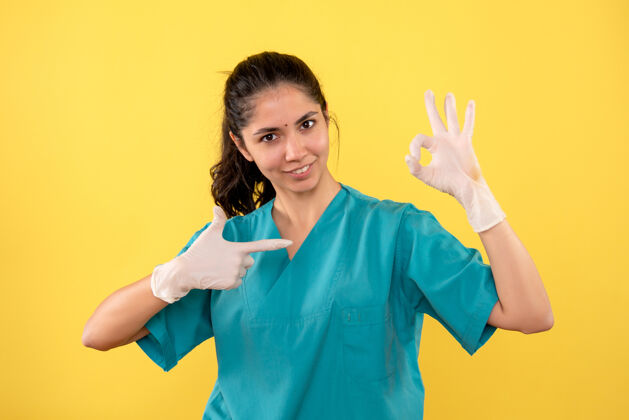 女人正面图：戴着乳胶手套的女医生正在做一个很好的手势人女医生漂亮