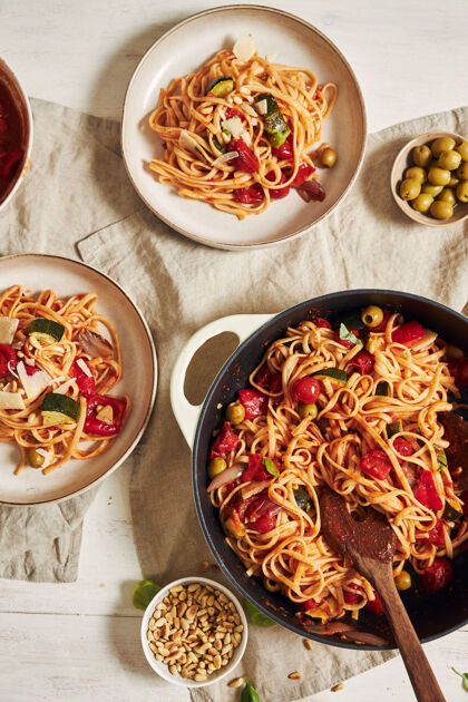新鲜特写镜头的意大利面与蔬菜和配料在一张白色的桌子上面食有机烹饪
