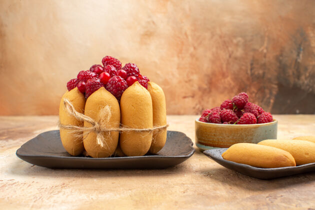 美食一个礼物蛋糕水果和饼干的侧视图在混合颜色的桌子上健康覆盆子水果