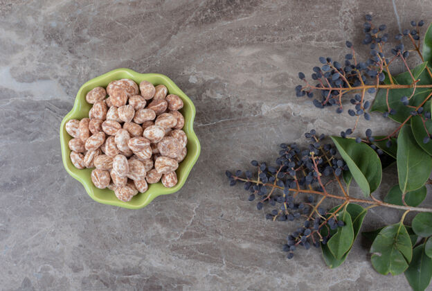 美味一碗放着葡萄和树叶的糖果 放在大理石表面糖叶子配料