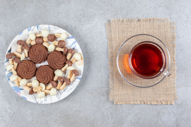 饼干一盘巧克力蘑菇饼干 旁边是一杯茶 背景是大理石高质量的照片糕点茶烘焙