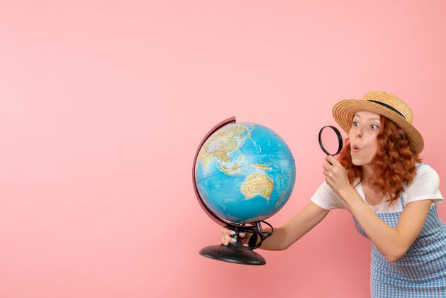旅游前视图女性游客用放大镜探索地球仪玻璃放大镜地球