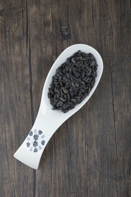 零食白勺健康的黑色葵花籽放在木桌上堆堆有机
