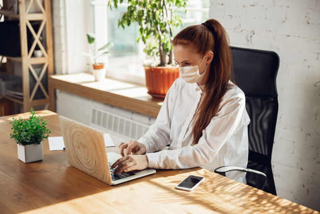 病人在冠状病毒或冠状病毒隔离期间独自在办公室工作的妇女戴着口罩爆发住院会议