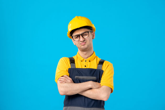工作前视图不高兴的男性工人穿着黄色制服在蓝色工程师承包商服务