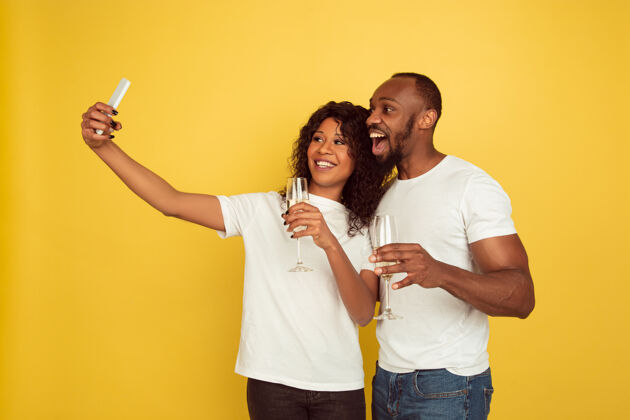 情侣一起自拍情人节庆祝 快乐的非洲裔美国夫妇隔离在黄色背景上人类情感的概念 面部表情 爱情 关系 浪漫的节日在一起情人男朋友