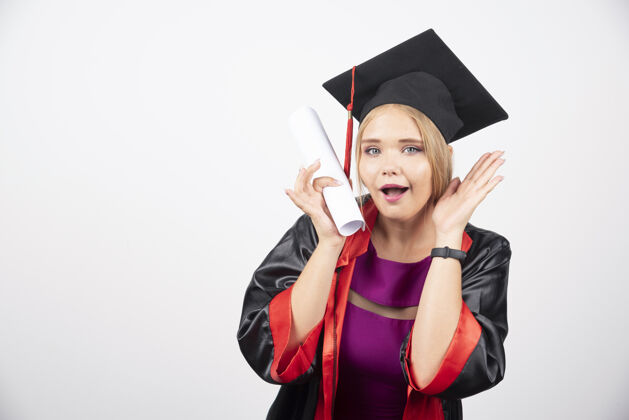 女性身着礼服的女学生获得了白色背景的毕业证书高质量的照片站立大学学术