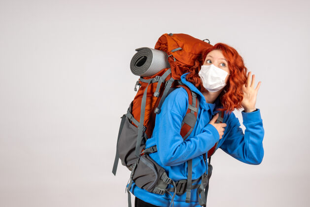 漂亮正面图女游客带着背包 戴着面具上山旅游人山徒步旅行