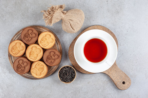 曲奇酸饼干和一杯茶放在木板上 旁边是一小碗茶叶和一个大理石背景的袋子高质量的照片糖尿病酸填补