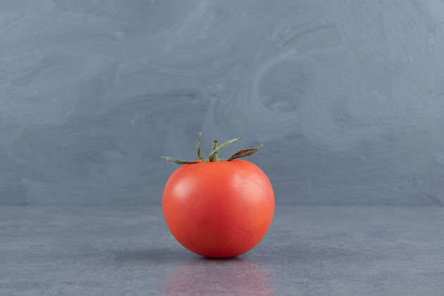 好吃的一个新鲜的红色番茄放在大理石表面好吃的食物西红柿
