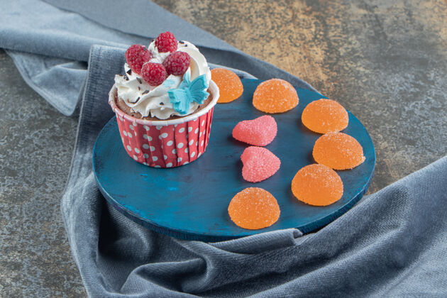 糖果美味的蛋糕装饰奶油和糖果在蓝板烘焙甜点糖果