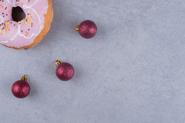 美味三个圣诞饰品和大理石表面的甜甜圈上釉甜点烘焙食品