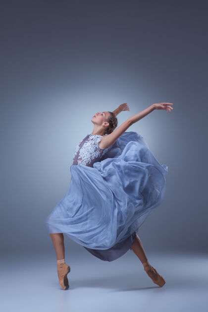 表演美丽的芭蕾舞演员在蓝色背景上穿着蓝色长裙跳舞运动当代芭蕾舞人