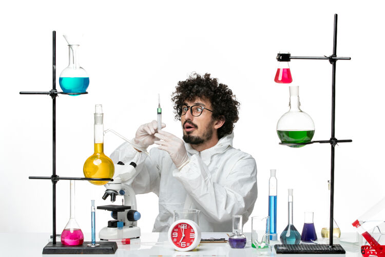 科学正面图身着特殊套装的年轻男科学家在白墙上打针化学病毒特殊