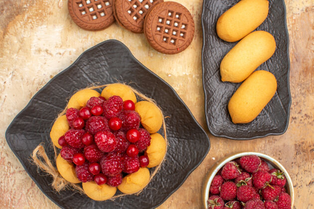 新鲜一个礼物蛋糕和饼干的特写镜头放在棕色盘子上的混合色桌子上蓝莓封闭盘子