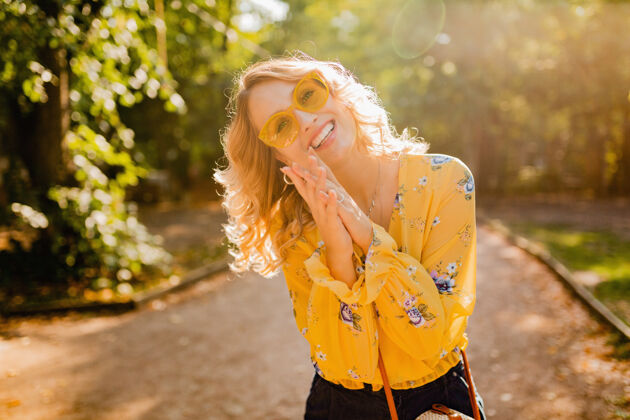 头发美丽的金发时尚微笑的女人穿着黄色衬衫戴着太阳镜的肖像年轻肖像街头