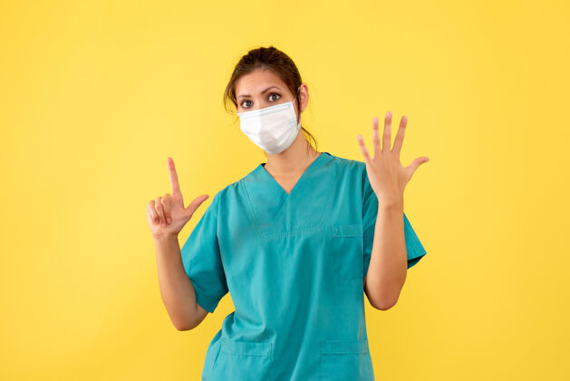 衬衫正面图黄色背景上穿着无菌口罩医用衬衫的女医生疾病女医生绝育