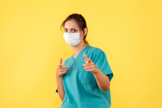 黄色正面图黄色背景上穿着无菌口罩医用衬衫的女医生脸衬衫人
