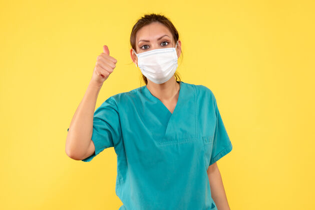 脸前视图黄色背景上穿着医用衬衫和面罩的女医生女医生视图医疗