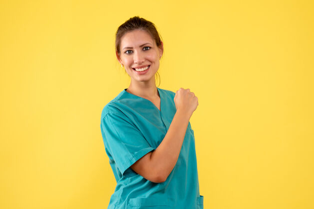 人前视图黄色背景上穿着医用衬衫的女医生正面视图肖像