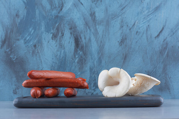 片香肠和牡蛎蘑菇放在木板上营养精致特写