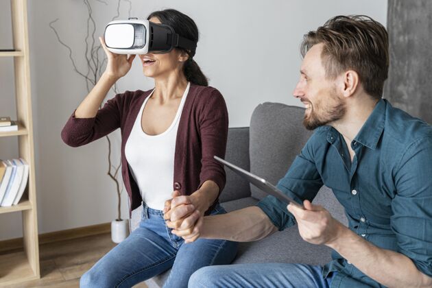 女人男人和女人在家里使用虚拟现实耳机和平板电脑家庭男人虚拟现实