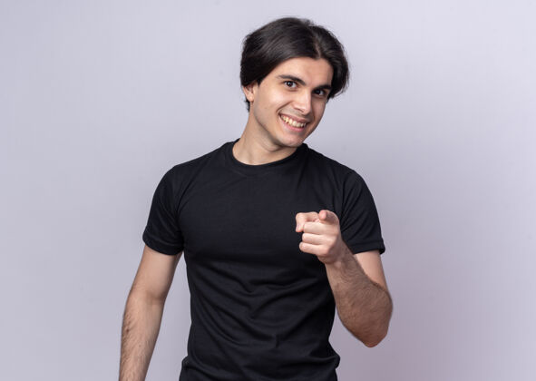 男人微笑着的年轻帅哥穿着黑色t恤在白色的墙上展示你的姿势微笑秀手势