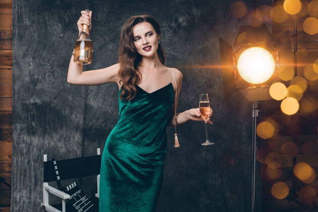 灯光年轻时尚性感的女人在电影院后台 用一杯香槟庆祝女人闪耀年轻