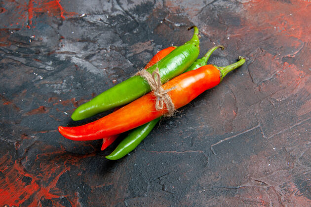 混合不同颜色和大小的辣椒的侧视图用绳子绑在一张混色桌上领带辣椒辣椒