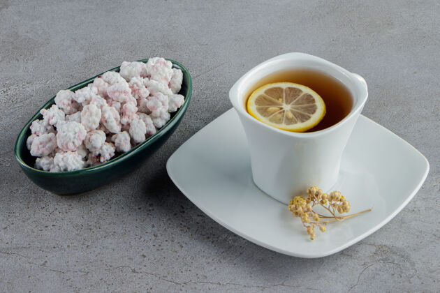 柠檬一碗甜甜的白糖果 一杯热茶放在石头上杯子美味薄荷
