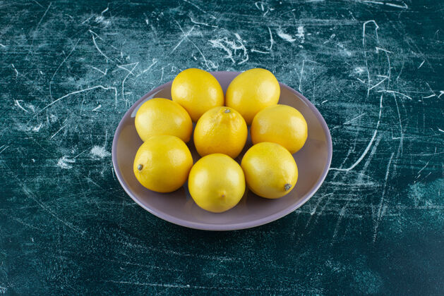 水果紫色盘子里放着酸黄色的柠檬生的食品成熟的