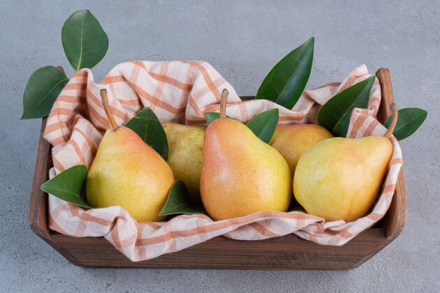 美味梨子 树叶和毛巾放在大理石背景的木篮里天然新鲜配料