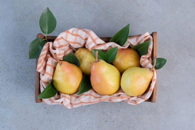 篮子梨子 树叶和毛巾放在大理石背景的木篮里美味美味饮食